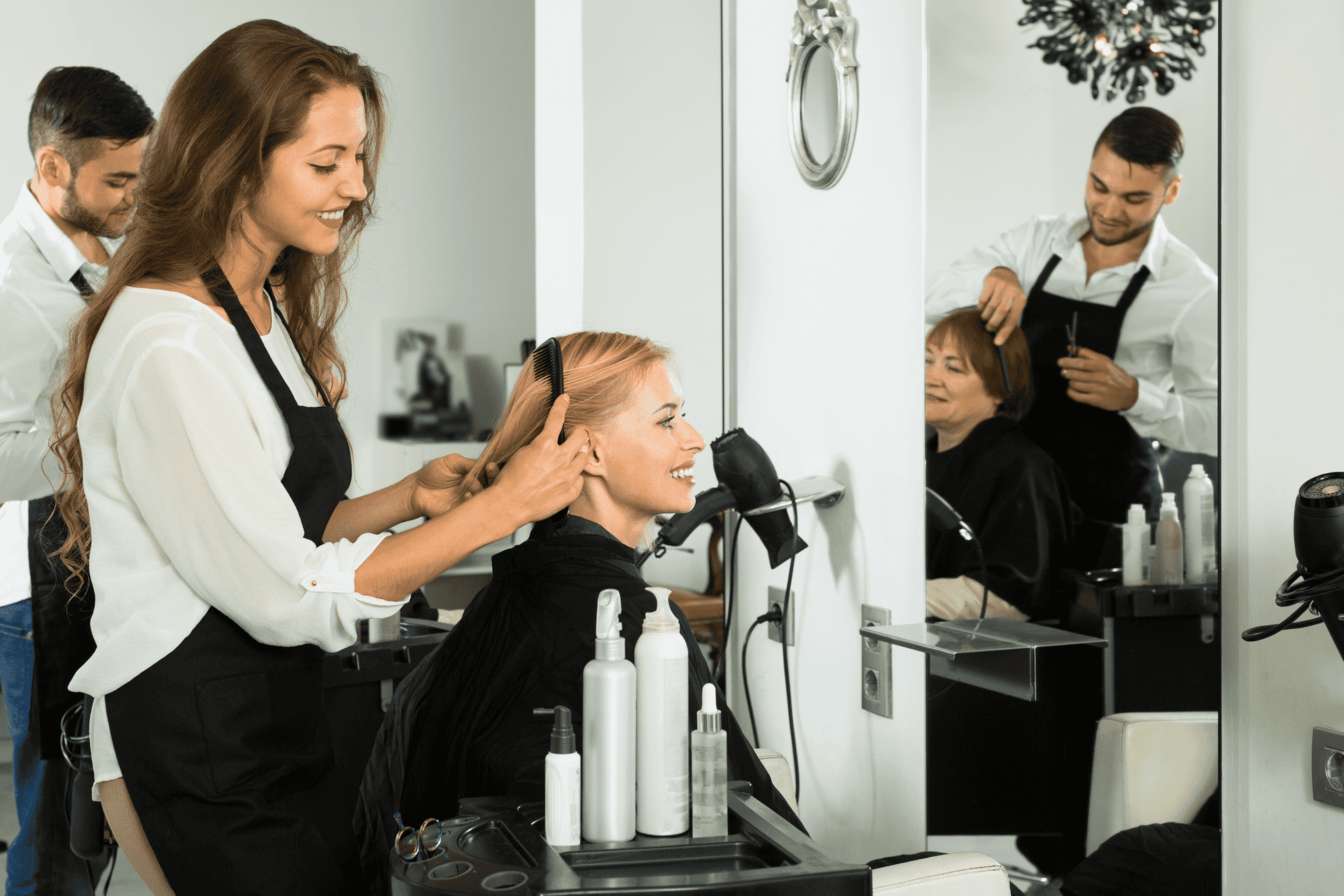 Hairdresser working on a client's haircut in a salon.