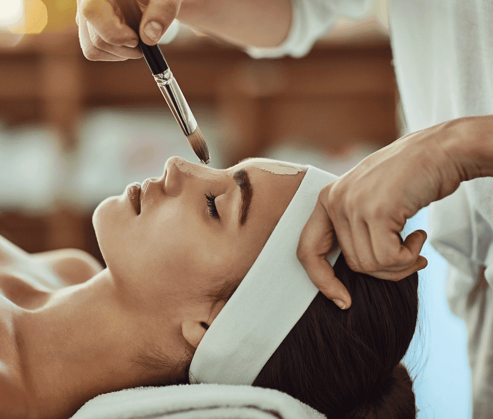 Woman receiving a facial treatment at a spa.
